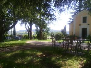 a yard with chairs and a building and trees at Villa Montrona RR in Imola