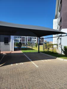 un pabellón en un estacionamiento junto a un edificio en SaronaC102 en Gaborone