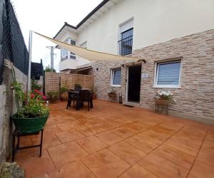 une terrasse avec une table et des chaises devant un bâtiment dans l'établissement Natura Cantabria, à Santillana del Mar