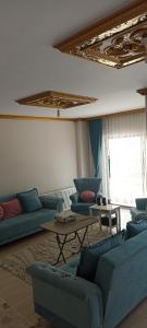 a living room with blue couches and a table at TERMAL LUX HOUSE in Yalova