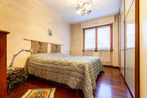 een slaapkamer met een bed, een lamp en een raam bij i cedri in Turijn