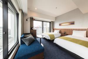 una camera d'albergo con due letti e una finestra di HOTEL METROPOLITAN KAWASAKI a Kawasaki