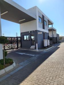 a building on a street with a cobblestone driveway at Sarona Studio A103 in Gaborone