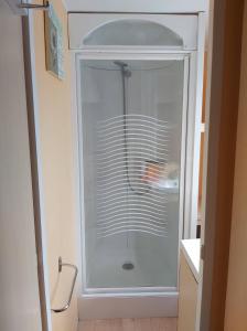 a white shower in a bathroom with a glass door at vacances familiales dans camping avec piscine in Fréjus