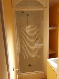 a glass shower in a bathroom with a sink at vacances familiales dans camping avec piscine in Fréjus