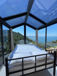 a bed in a room with a view of the ocean at CİVRA BUNGALOV in Sürmene