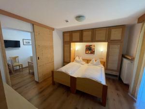 une grande chambre avec deux lits et un salon dans l'établissement Hotel Meisules, à Selva di Val Gardena