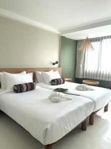 - une chambre avec 2 lits dotés de draps et d'oreillers blancs dans l'établissement HOTEL NUU CHIANG MAI, à Chiang Mai