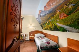 Zimmer mit einem Bett und einem Wandgemälde in der Unterkunft Willa Kubik in Zakopane