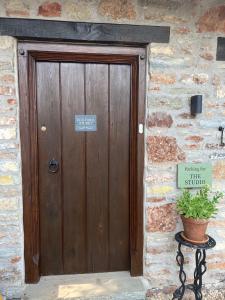 a wooden door in a stone building with a potted plant at Studio Apartment in Wells