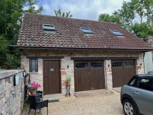 a brick house with two sets of garage doors at Studio Apartment in Wells