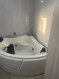 eine weiße Badewanne in einem weißen Zimmer in der Unterkunft Gyutei Citi Hotel and Suite in Uyo