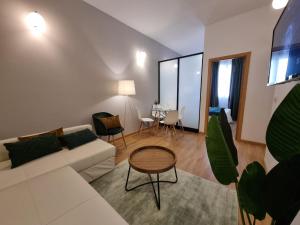 sala de estar con sofá blanco y mesa en Apartamentos San Isidro, en Madrid