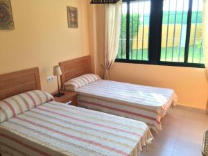 a bedroom with two beds and a window at APARTAMENTO DE 2 DORMITORIOS APARTACLUB in Chiclana de la Frontera +8 photos