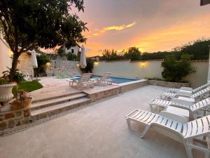 a patio with lounge chairs and a swimming pool at Apartments Villa Mike in Mostar