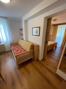 a living room with a couch and a bed at Hotel Meisules in Selva di Val Gardena