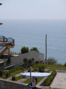 a woman sitting next to a statue of a surfboard at Hostel & Surfcamp 55 in Ericeira