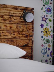 1 dormitorio con cabecero de madera y lámpara en Hostel & Surfcamp 55, en Ericeira