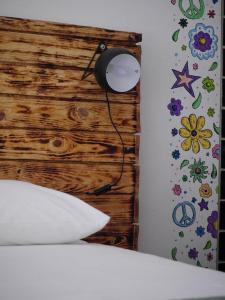 a bedroom with a wooden headboard and a lamp at Hostel & Surfcamp 55 in Ericeira