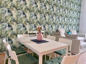 a dining room with a table and chairs with a tropical wallpaper at Boutique HomeR1274 Apartment #3bedroom #freeparking in Budapest