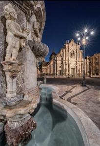een fontein voor een gebouw 's nachts bij Rainbow House in Catania