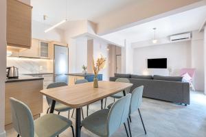a kitchen and a dining room with a table and chairs at Phaedrus Living Athens City Center Geraniou in Athens