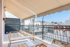 a balcony with chairs and a view of the city at Phaedrus Living Athens City Center Geraniou in Athens
