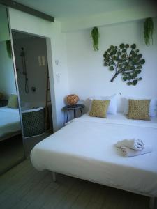 Q Village - Poleg Beach في نتانيا: غرفة نوم بسرير ابيض كبير عليها مناشف