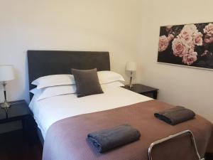 una camera da letto con un grande letto con due cuscini sopra di Leisurely Manor - spacious three bedroom home in Fremantle a Fremantle