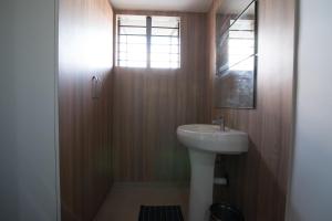 y baño con lavabo y espejo. en Kanasu StayHome, en Chikmagalur