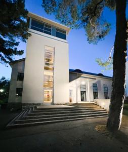 ein weißes Gebäude mit einer Treppe davor in der Unterkunft LaSpa Beach House in Laulasmaa