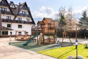 a playground with a tree house and a slide at Willa Kubik in Zakopane