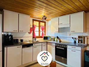 a kitchen with white appliances and a wooden ceiling at Family M Apartments 5 in Kappel bei Olten