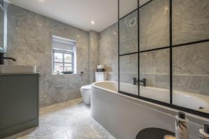 une salle de bain avec baignoire et toilettes dans l'établissement Tern Cottage 6, à Burnham Market 34 autres photos