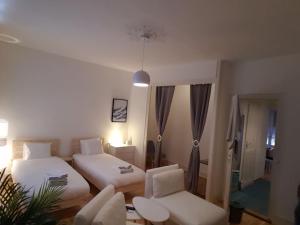 Un dormitorio con dos camas y un sofá y una silla. en DIAMOND appartement au centre de Genève, en Ginebra