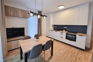 a kitchen and dining room with a table and chairs at Apartmá v klidné lokalitě Krkonoš. in Pec pod Sněžkou