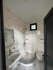 baño blanco con bañera y aseo en Lilus Apartament Shekvetili, en Shekhvetili