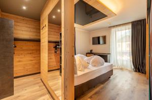 1 dormitorio con 1 cama en una habitación con paredes de madera en Suite del Podesta' en Moena
