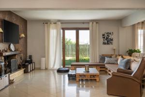 sala de estar con sofá y mesa en Villa Sofia en Anavissos
