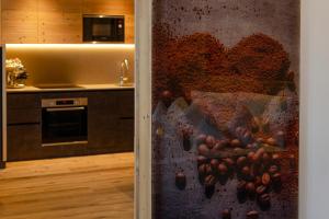 a kitchen with a wall with a painting on it at Suite del Podesta' in Moena