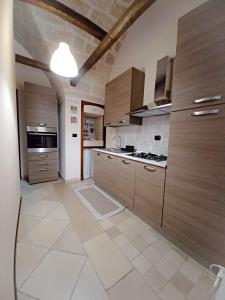 Il comprend une grande cuisine avec des placards en bois et du carrelage. dans l'établissement La piccola maison, à Mola di Bari