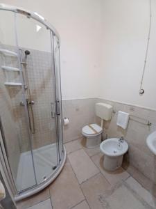 een badkamer met een douche, een toilet en een wastafel bij La piccola maison in Mola di Bari