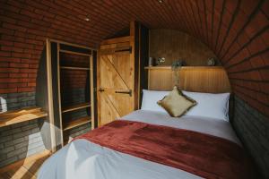a bedroom with a large bed in a brick wall at Otters View in Rhayader