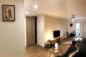 sala de estar con sofá, mesa y TV en T2 Beaux Arts climatisation loggia parking privé en Montpellier