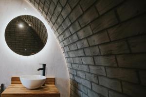 a bathroom with a sink and a brick wall at Otters View in Rhayader