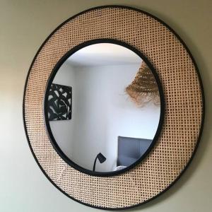 a round mirror hanging on a wall with a room at T2 Beaux Arts climatisation loggia parking privé in Montpellier