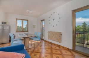 una sala da pranzo con tavolo e sedie blu di Apartment Moderna Soline a Dobrinj