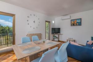 a living room with a table and a blue couch at Apartment Moderna Soline in Dobrinj
