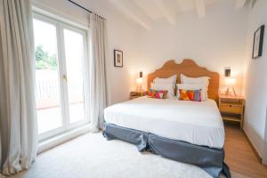 a bedroom with a large bed and a large window at Hotel Maïa in Ciutadella