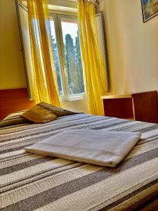 a bed in a bedroom with yellow curtains and a window at Innpiero in Taormina